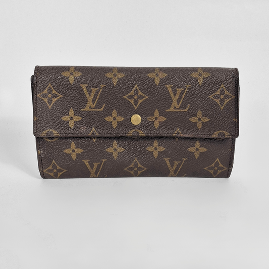 Designer wallet with monogram pattern on a light gray background