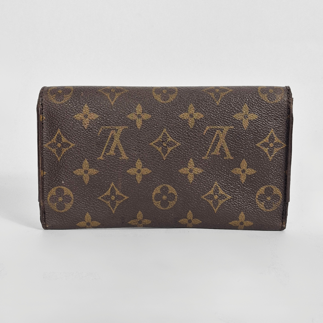 Designer wallet with monogram pattern on a light gray background