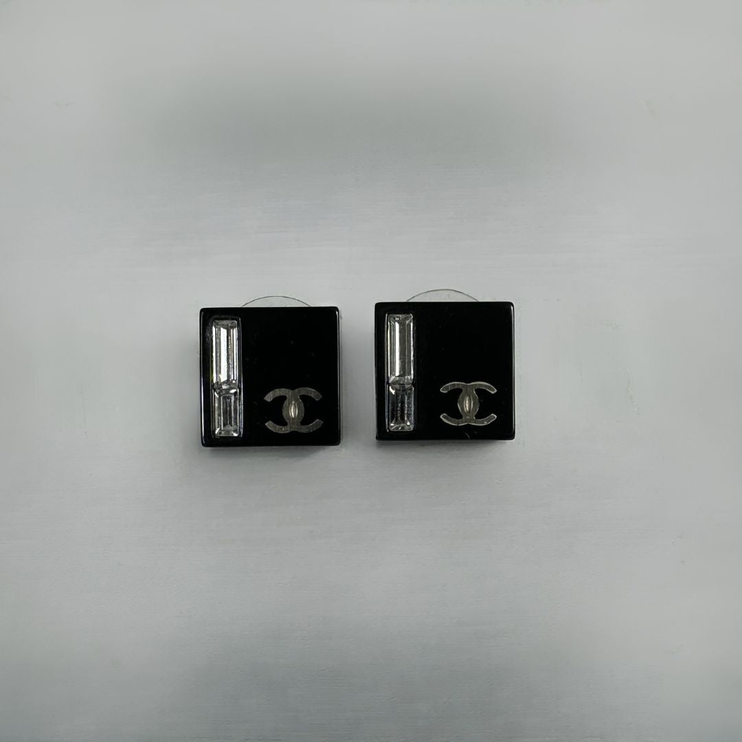 Chanel black earrings on white background