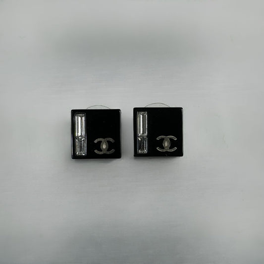 Chanel black earrings on white background