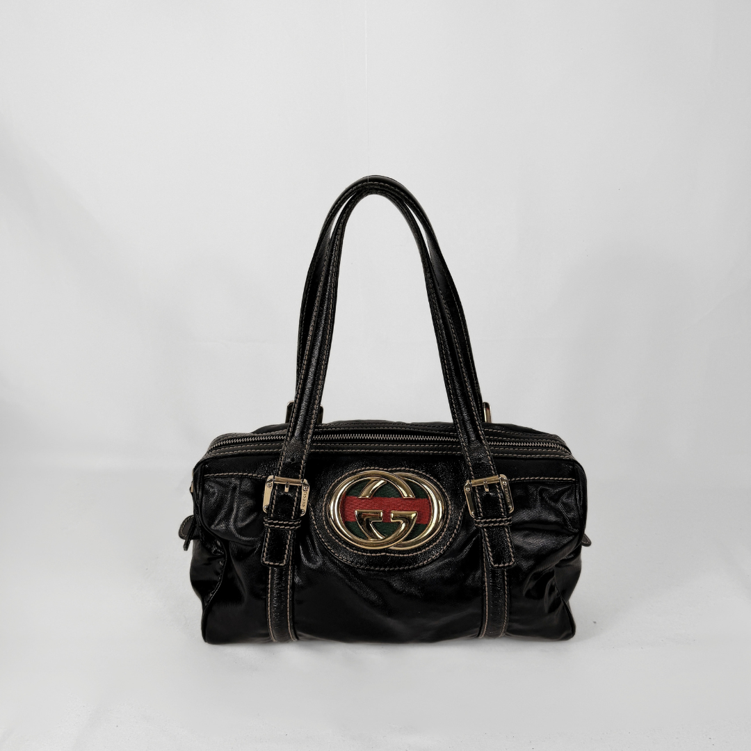 Gucci Dialux Britt Boston bag in signature Dialux canvas displayed on a light grey background.