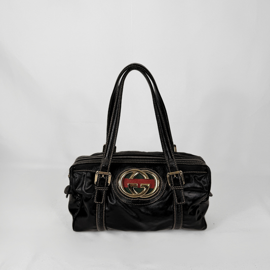 Gucci Dialux Britt Boston bag in signature Dialux canvas displayed on a light grey background.