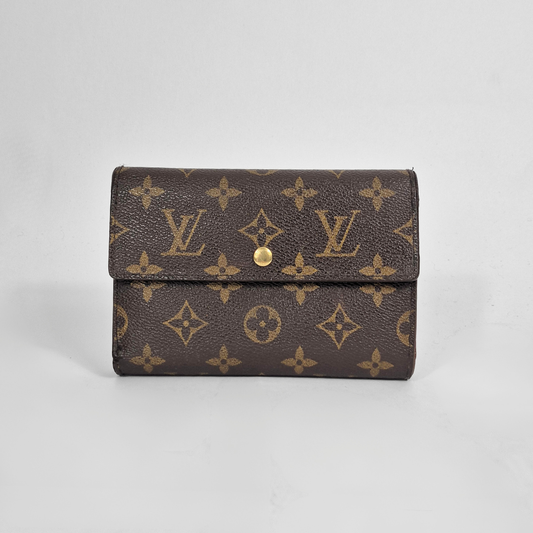 Louis Vuitton wallet with monogram pattern on a light gray background