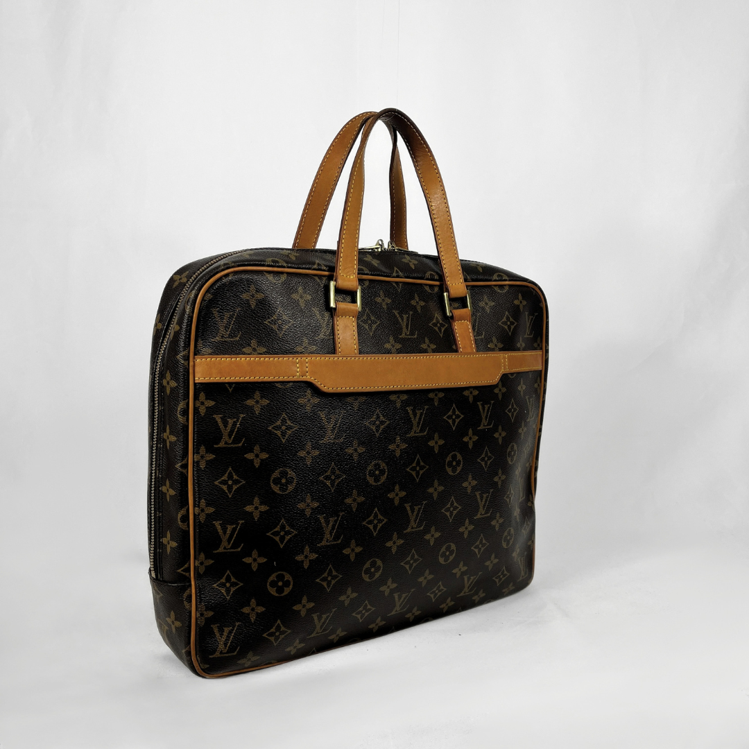 A Louis Vuitton monogram canvas briefcase or laptop bag with tan leather handles and trim, photographed on a white studio background.