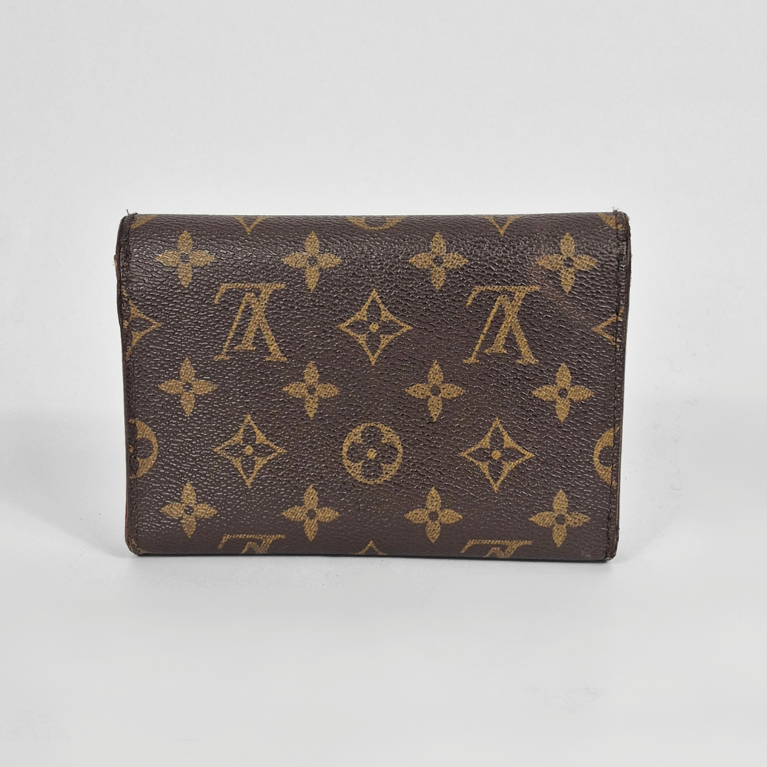 Brown wallet with gold monogram pattern on a white background