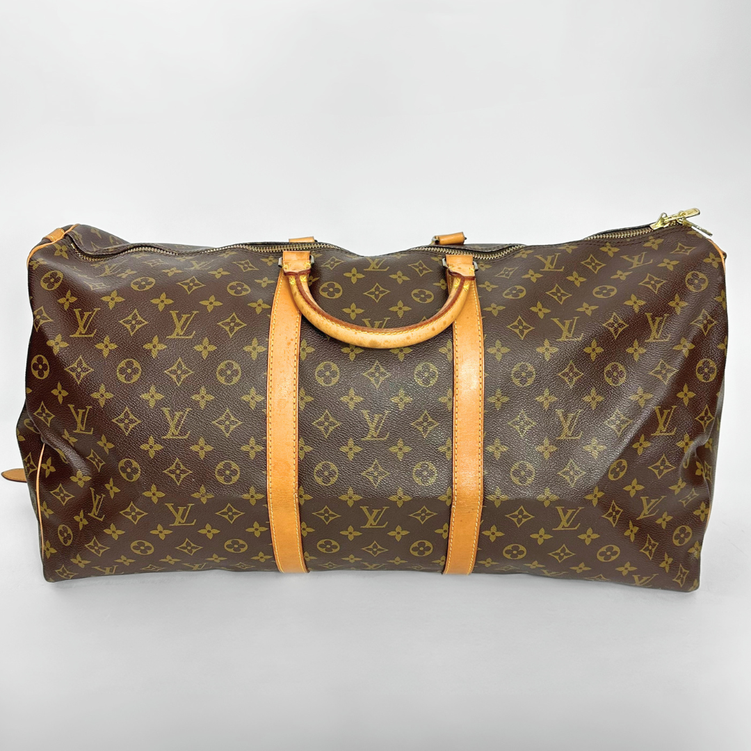 Brown travel bag with yellow monogram pattern on a white background