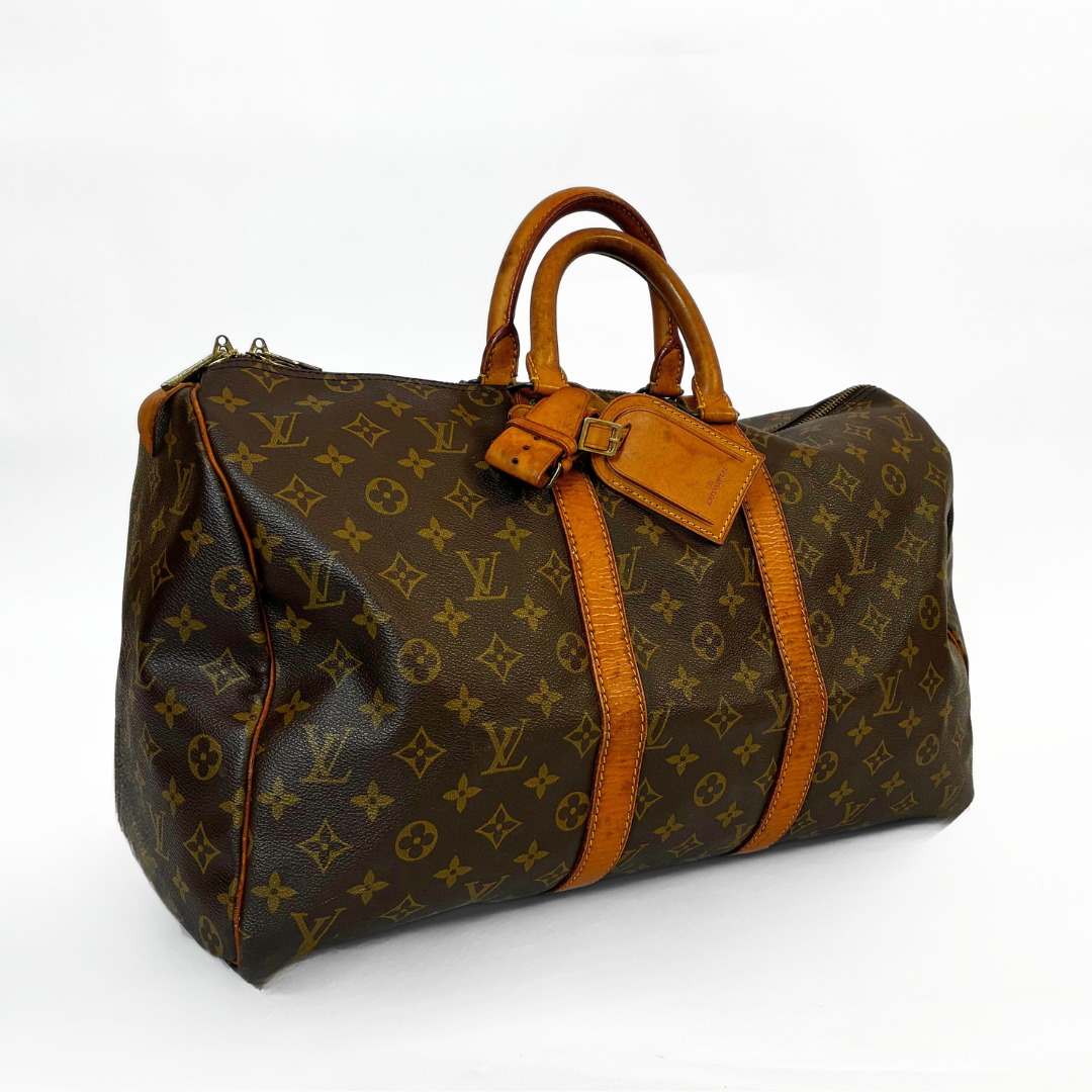 Brown leather handbag with orange accents on a white background