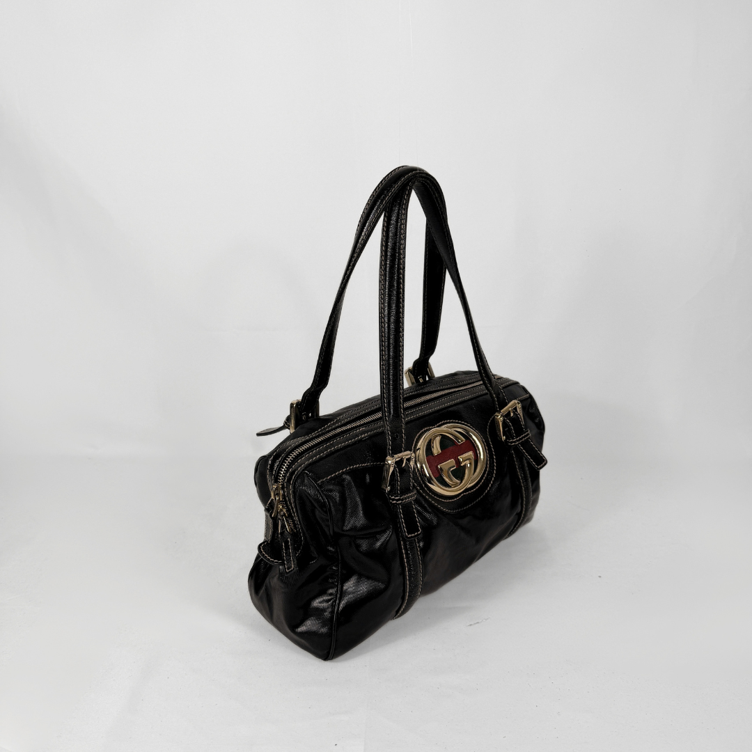 Gucci Dialux Britt Boston bag in signature Dialux canvas displayed on a light grey background.