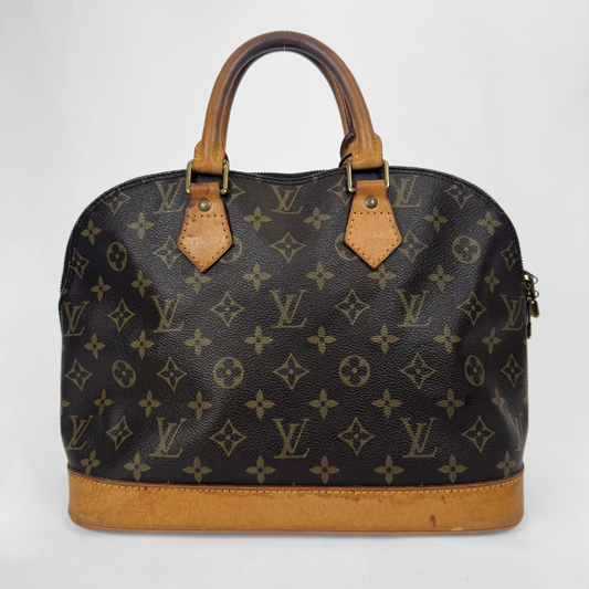 A Louis Vuitton monogram canvas dome handbag with tan leather handles and trim, photographed against a plain light gray background.