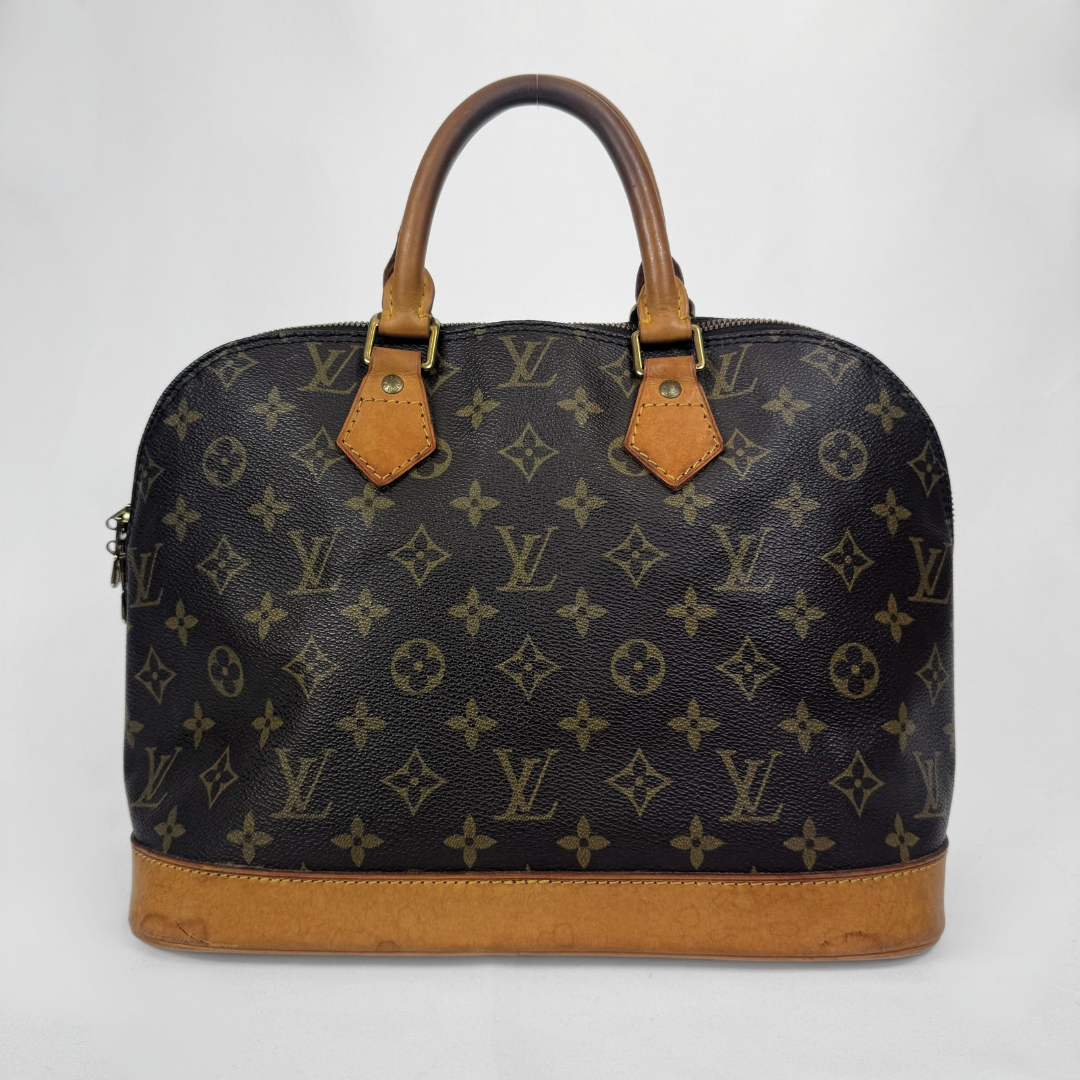 Louis Vuitton monogram canvas dome handbag with tan leather handles and base trim, photographed against a plain light gray background.