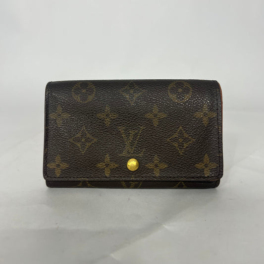 Brown wallet with gold monogram pattern on a white background