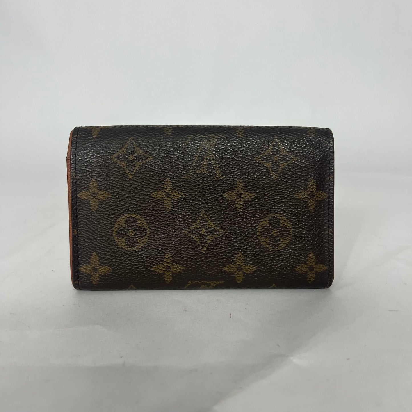 Louis Vuitton wallet with monogram pattern on a white background