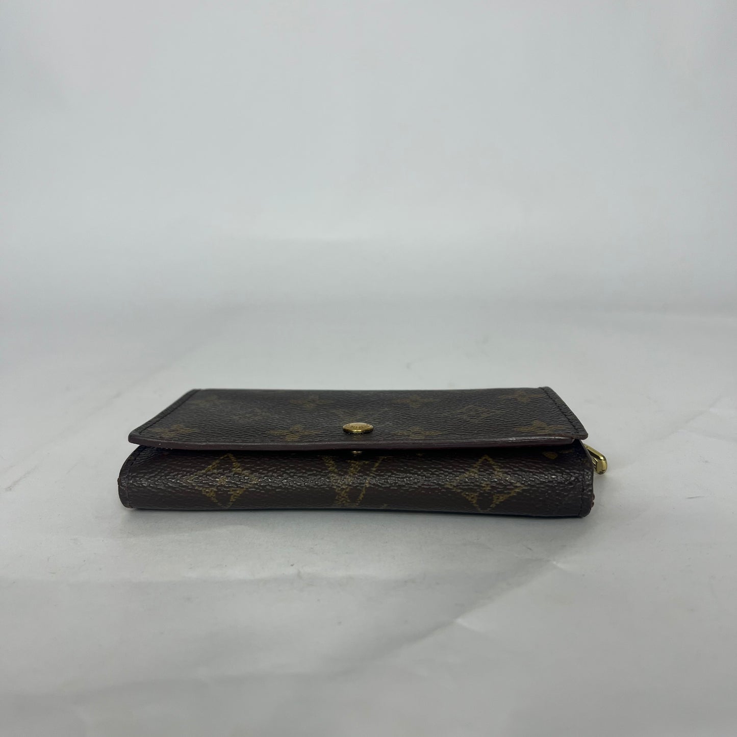 Black leather wallet with gold accents on a white background