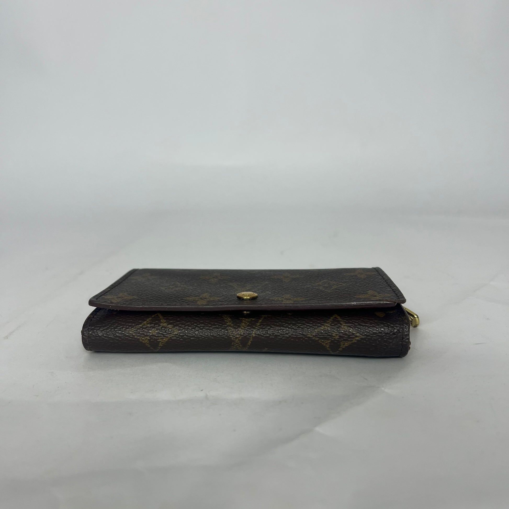 Black leather wallet with gold accents on a white background
