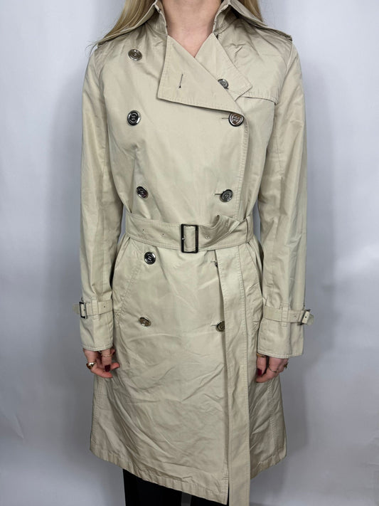Beige trench coat worn by a person on a white background